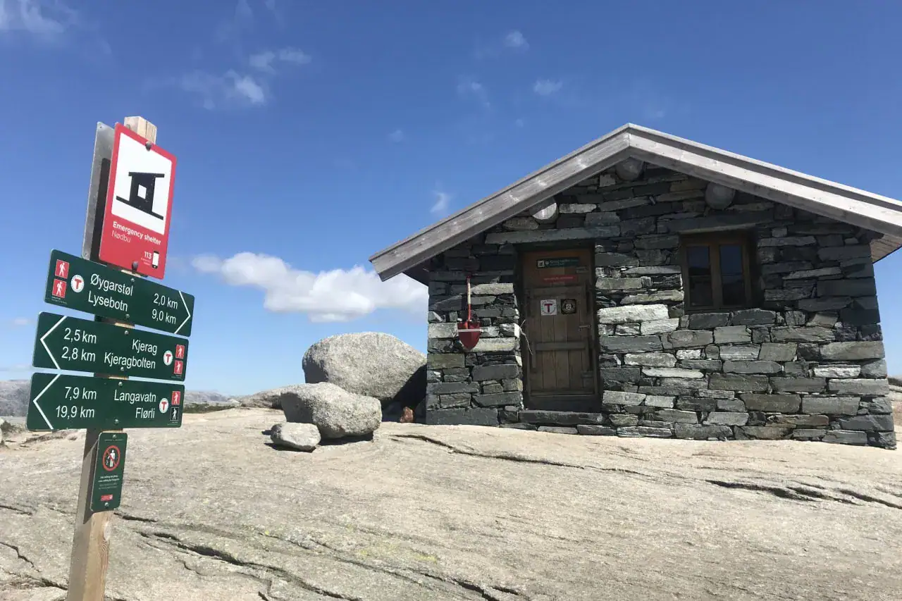 Kjerag emergency shelter on the mountain plateau above Lysebotn with trail signs to Kjeragbolten, Øygardstøl and Flørli