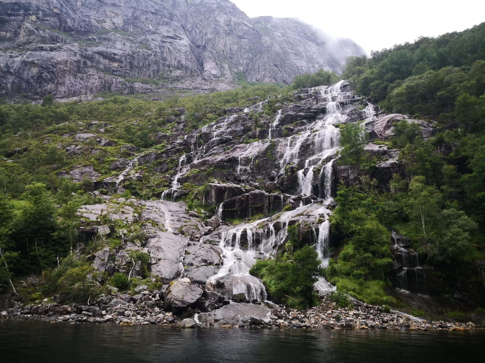 Waterfall in the Lysefjord with scenic views of the mountains and green landscape, a popular destination for nature lovers and hiking enthusiasts, perfect for fjord experiences in Norway.